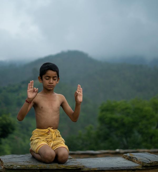 Person meditating peacefully with a calm natural background.