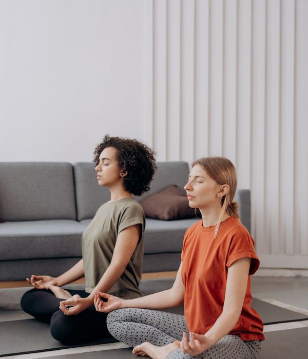 Woman practicing a peaceful yoga pose in a bright room.
